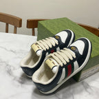 Gucci unisex sneakers pair with cream laces, navy uppers, and green/red/white stripe accents
