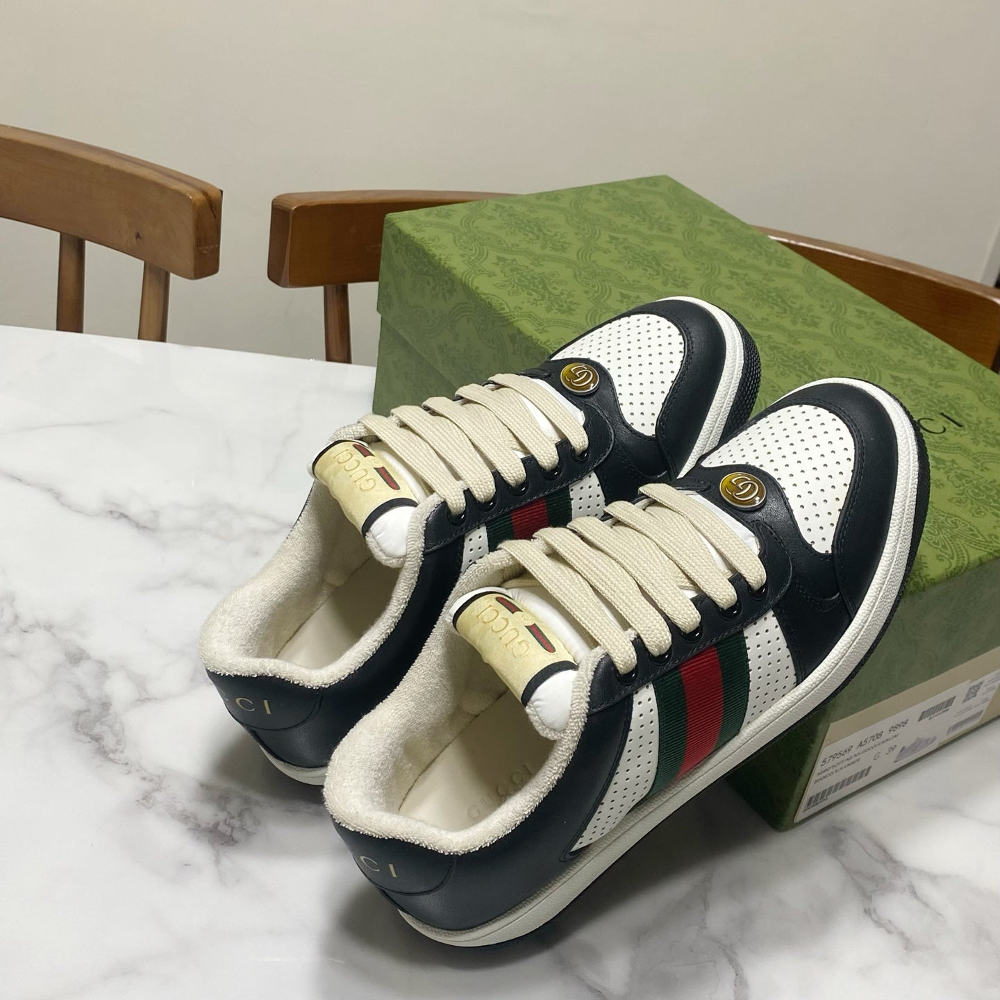 Gucci unisex sneakers pair with cream laces, navy uppers, and green/red/white stripe accents