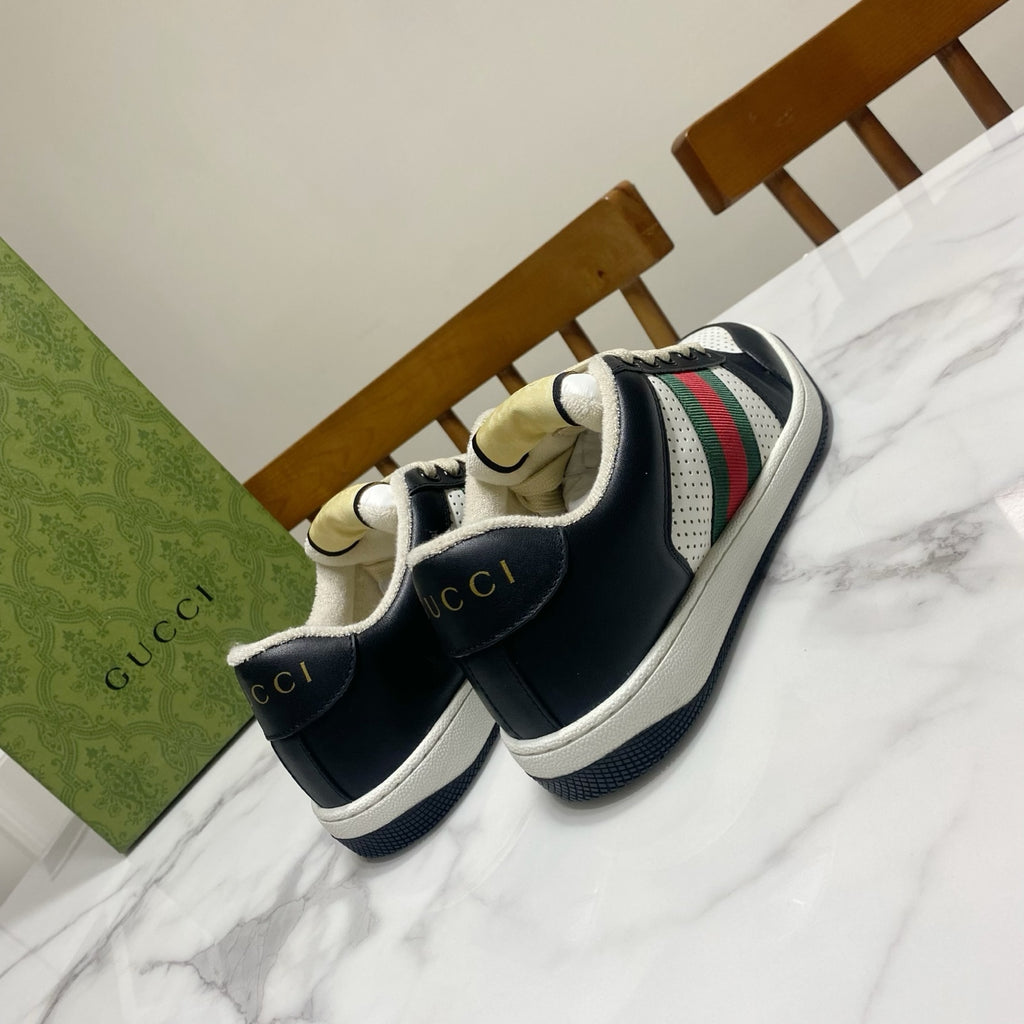 Gucci unisex sneakers with navy upper, white sole, and multicolor web stripe at heel
