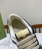 Gucci unisex sneaker tongue detail with Gucci logo patch, cream lining, navy collar