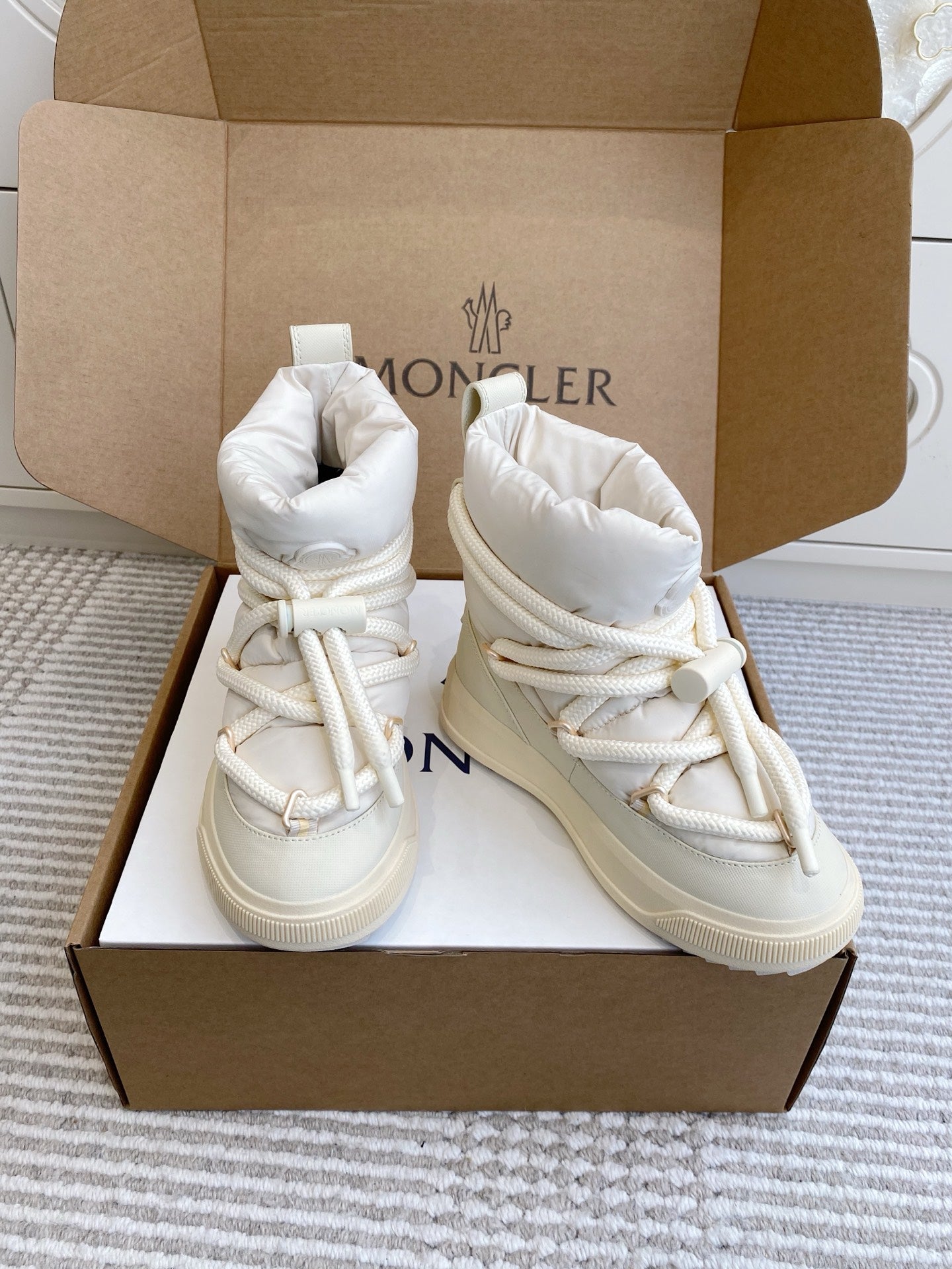 Pair of white Moncler high-top sneakers with lace-up fronts and padded ankle cuffs