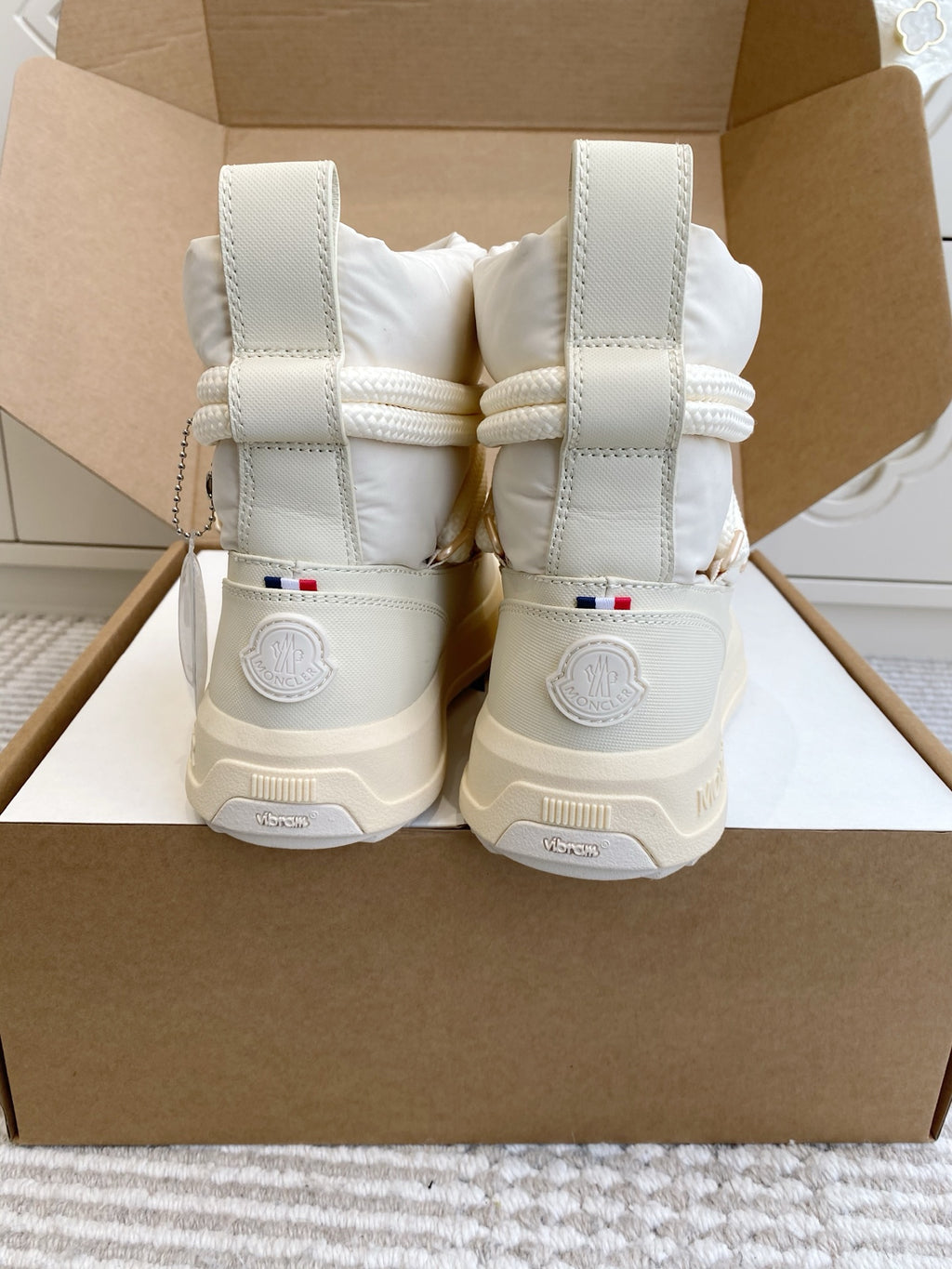 White Moncler high-top sneakers with lace-up closure and hook-and-loop back patches