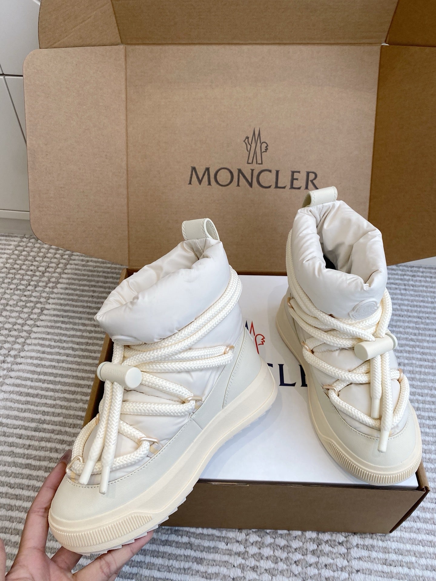 White Moncler high-top sneakers with lace-up ties, cushioned collar, in open box
