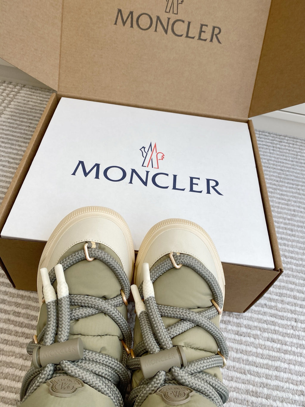 Moncler sneakers viewed from above in box, sage uppers, gray laces, white rubber soles