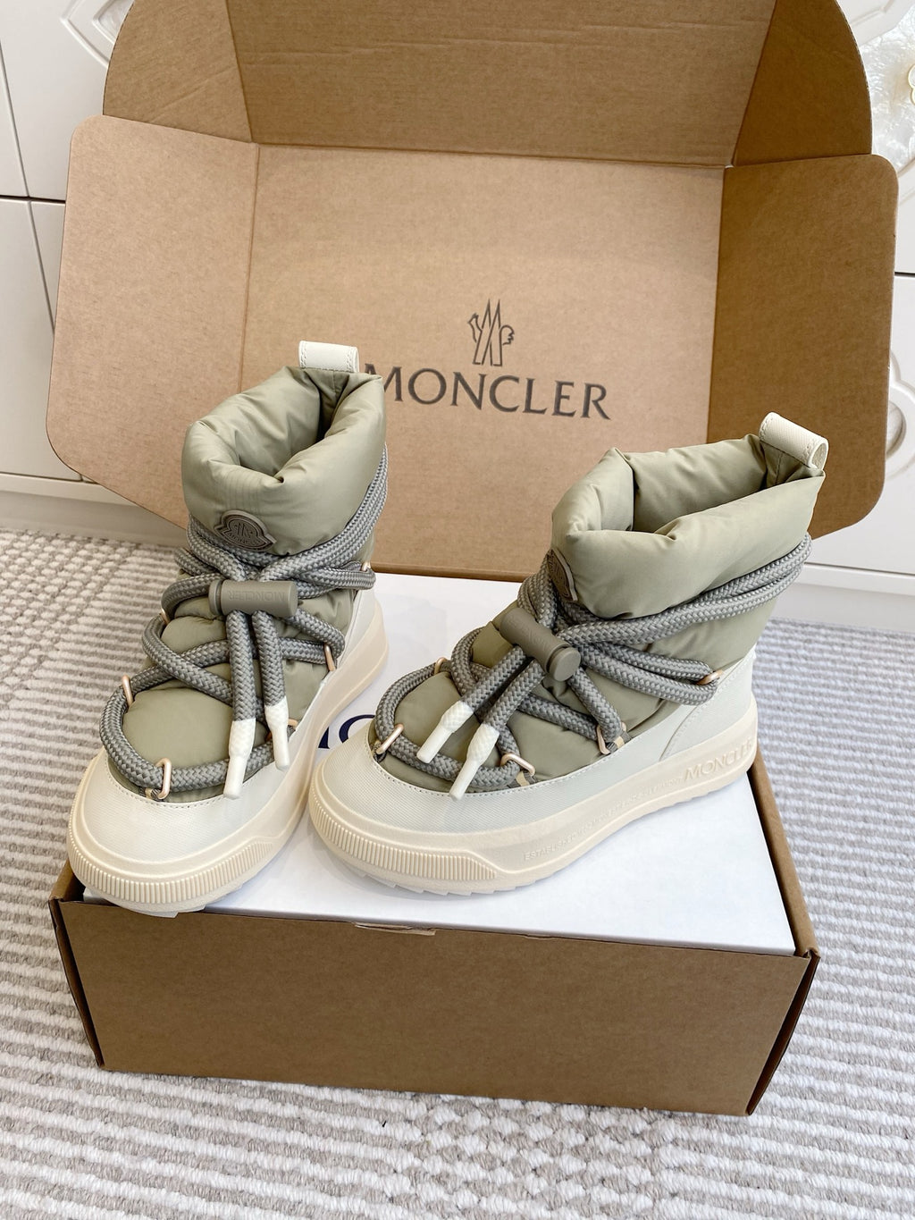 Moncler high-top sneakers in box, sage green uppers, gray laces, and white rubber sole