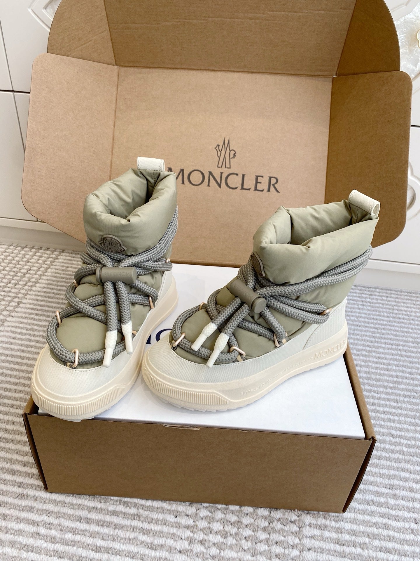 Moncler high-top sneakers in box, sage green uppers, gray laces, and white rubber sole