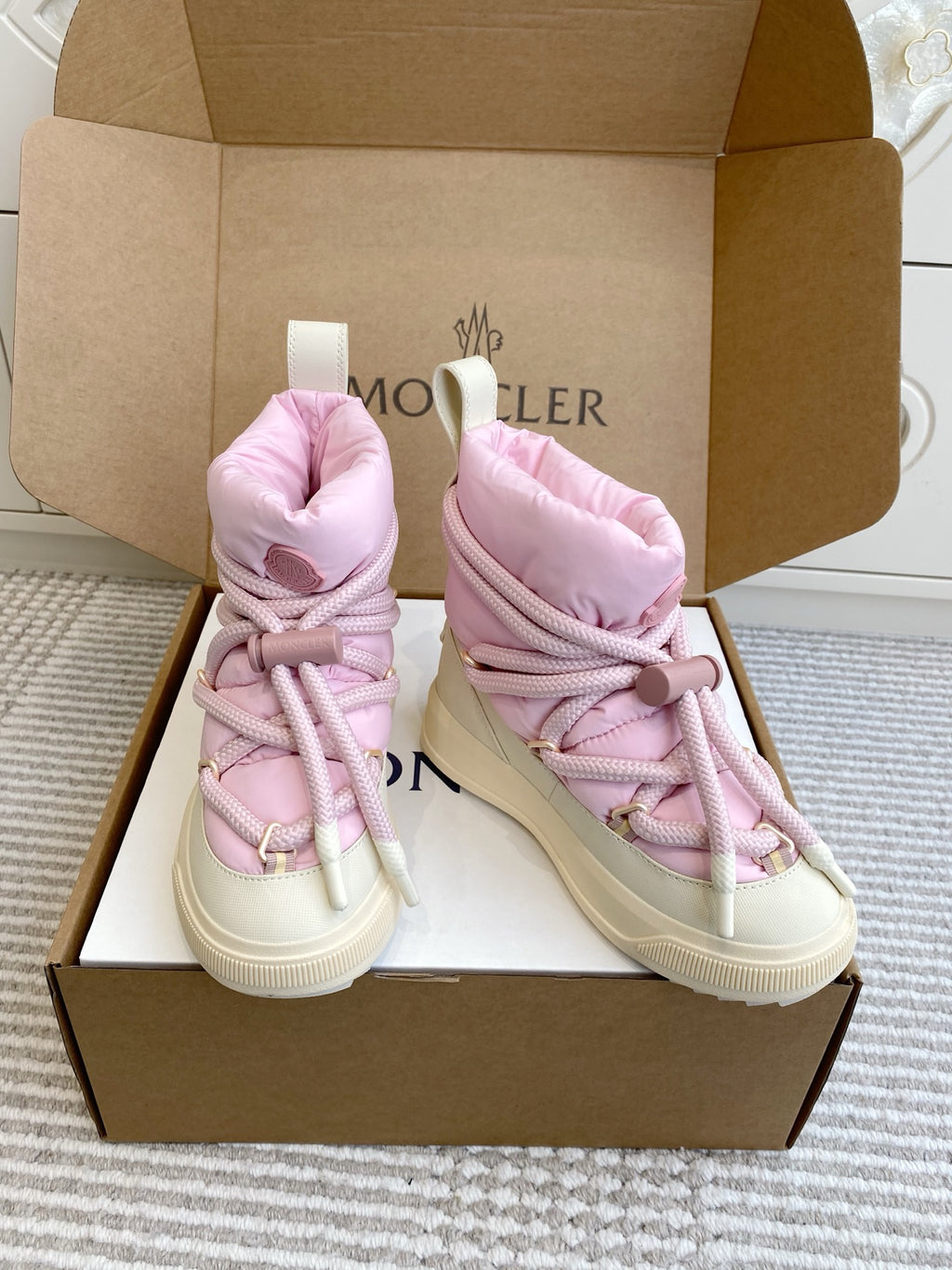 Moncler pink puffer sneakers, diagonal view with white sole and lace-up front
