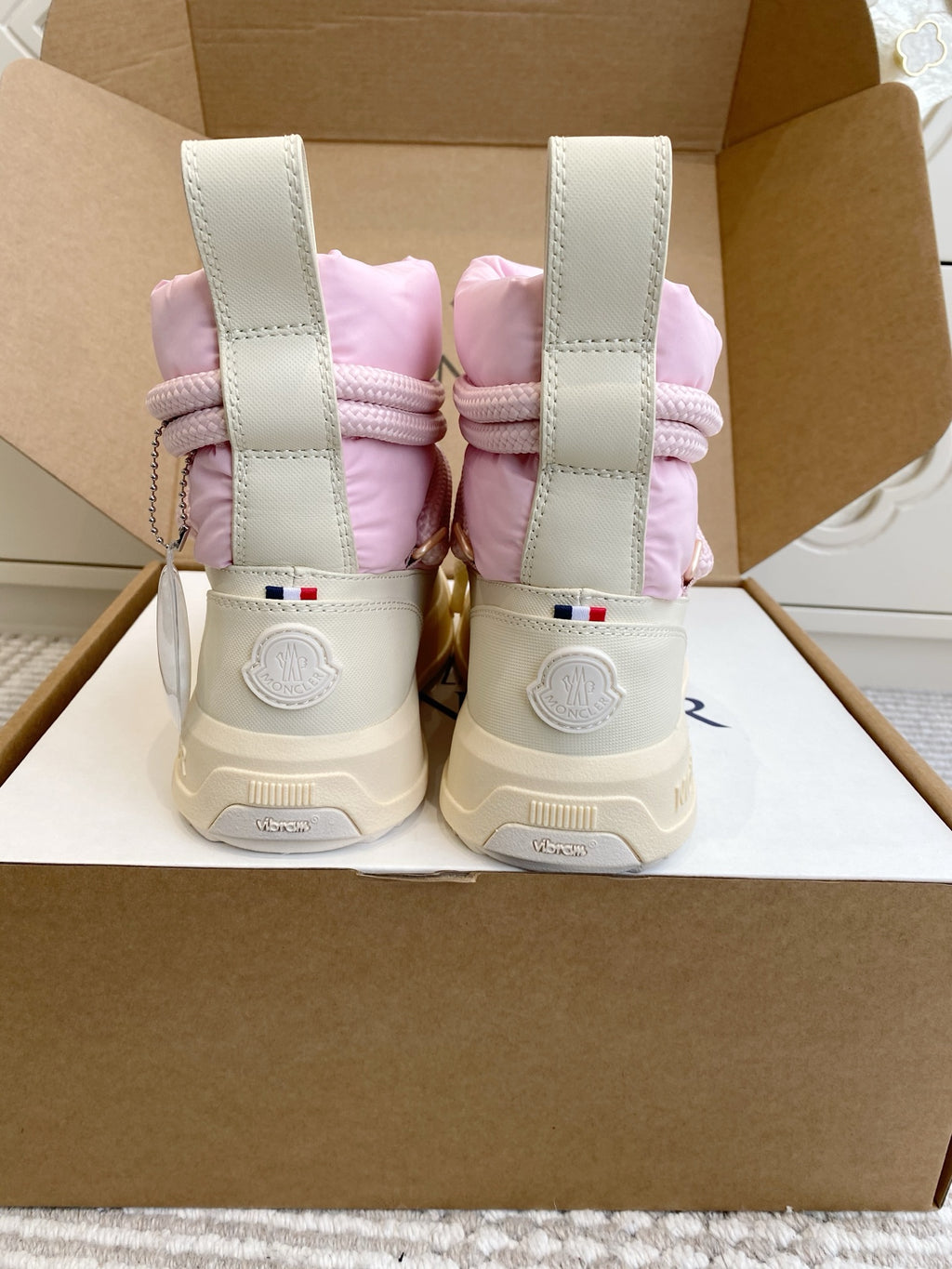 Moncler pink puffer sneakers back view with white heel straps and logo patch