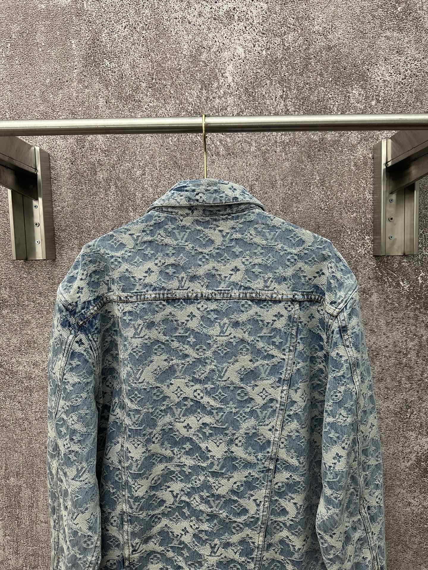 Blue denim jacket back view with all-over monogram pattern and buttoned yoke seam