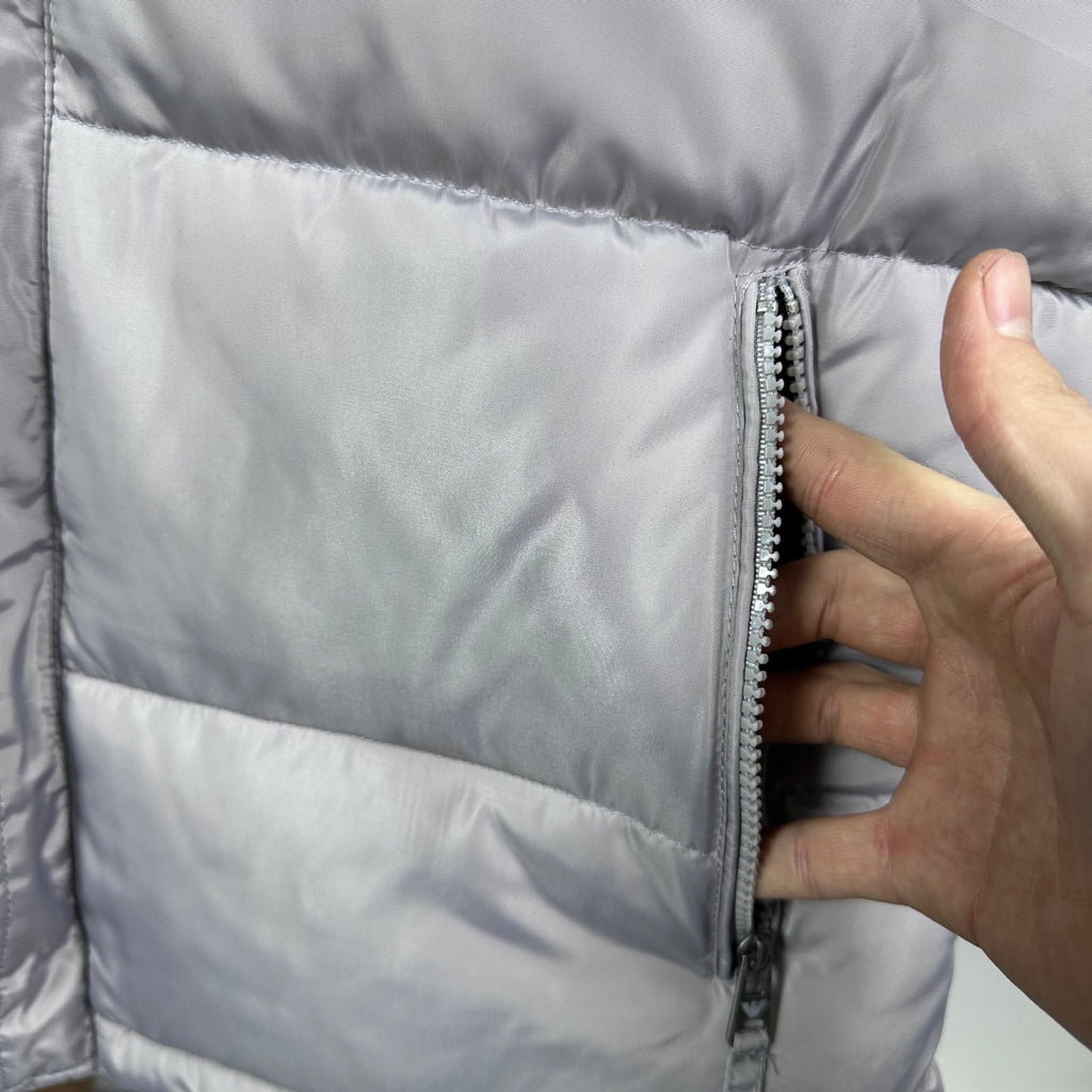 Amiri hooded puffer vest, light gray, close-up of side zipper and quilted panels