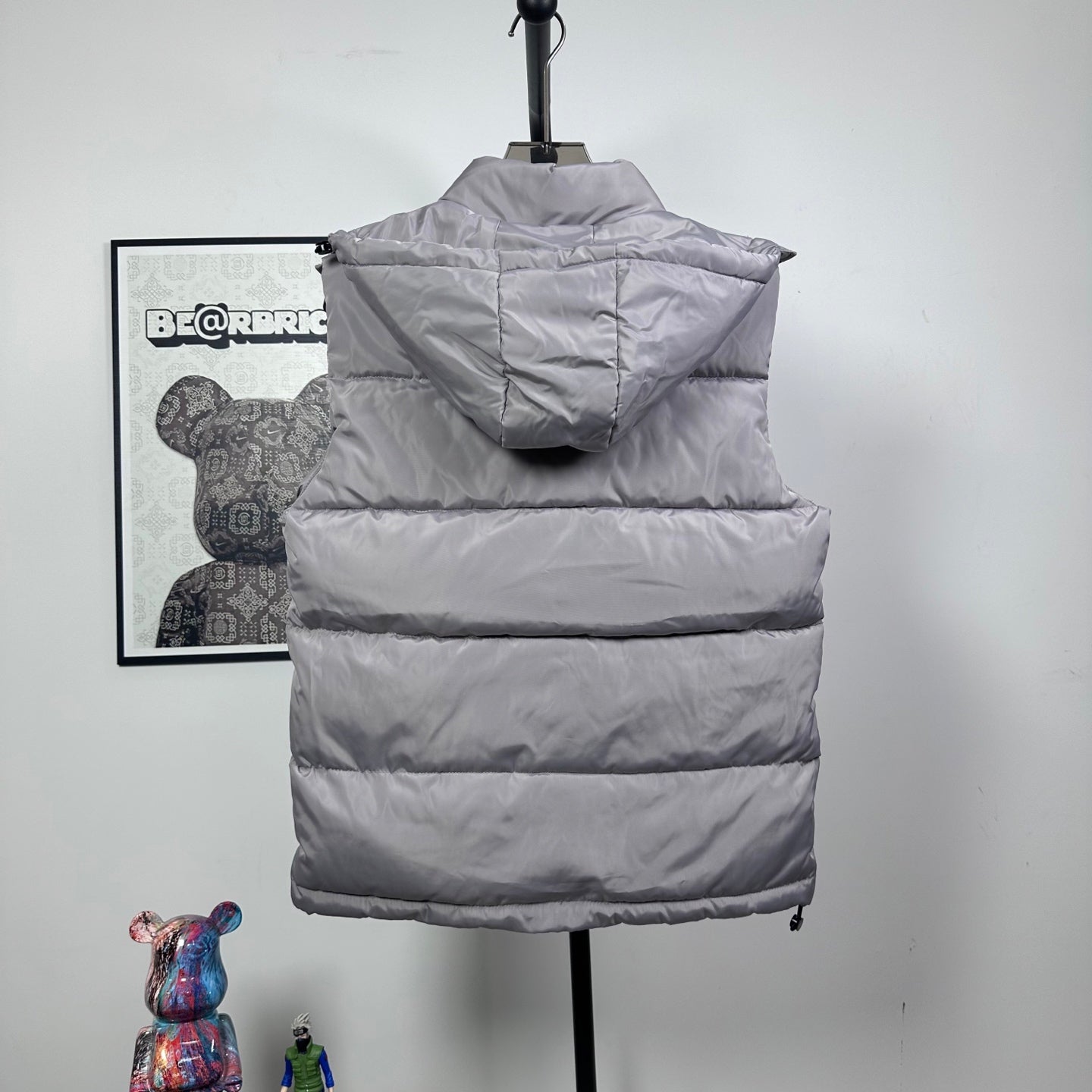 Amiri hooded puffer vest, light gray, rear view with hood and stitched baffles