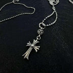 Chrome accessory necklace with small cross pendant and dangling ribbon charm