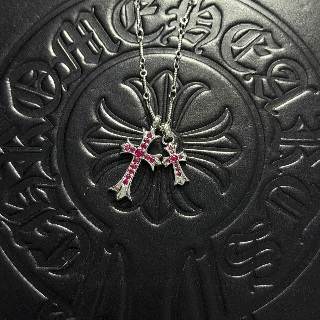 Silver-tone cross pendant necklace with red gem accents and double chain