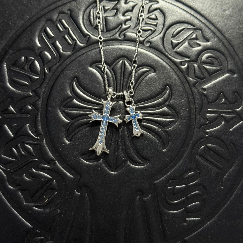 Silver-tone cross pendant necklace with blue gem accents and double chain