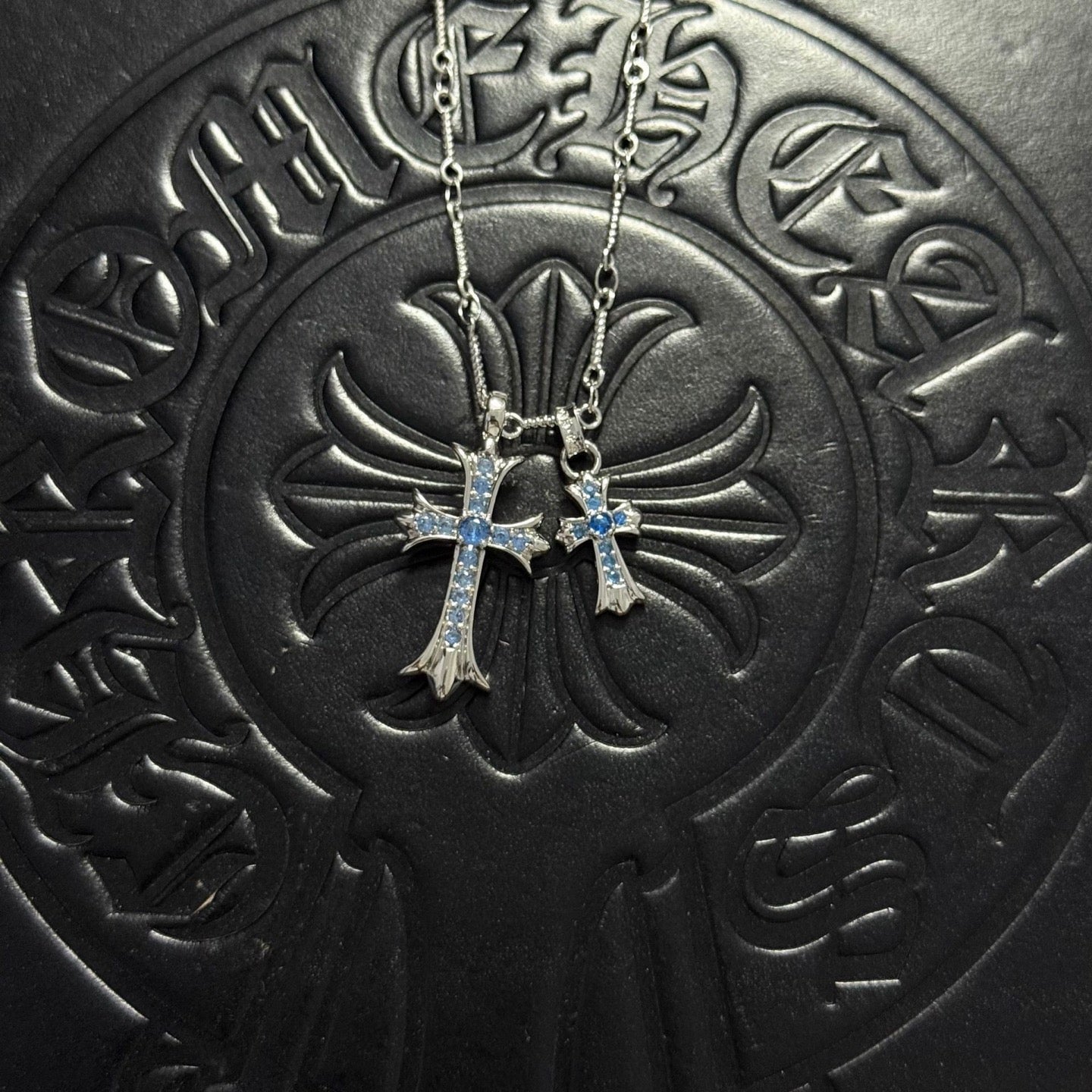 Silver-tone cross pendant necklace with blue gem accents and double chain