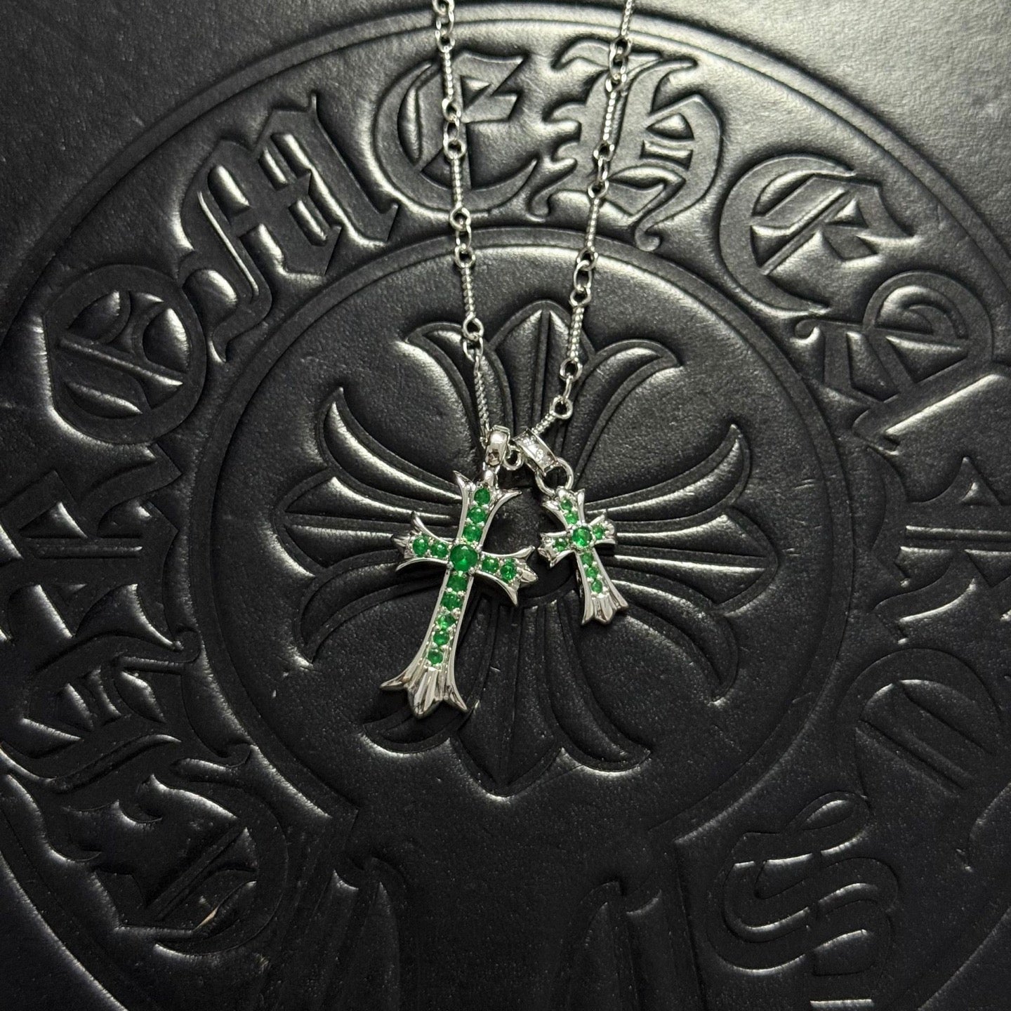 Silver-tone cross pendant necklace with green gem accents and double chain