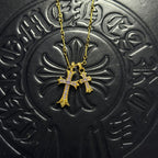 Gold-tone cross pendant necklace with purple gem accents on chain