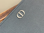 Dior small bag front metal logo emblem on dark textured leather