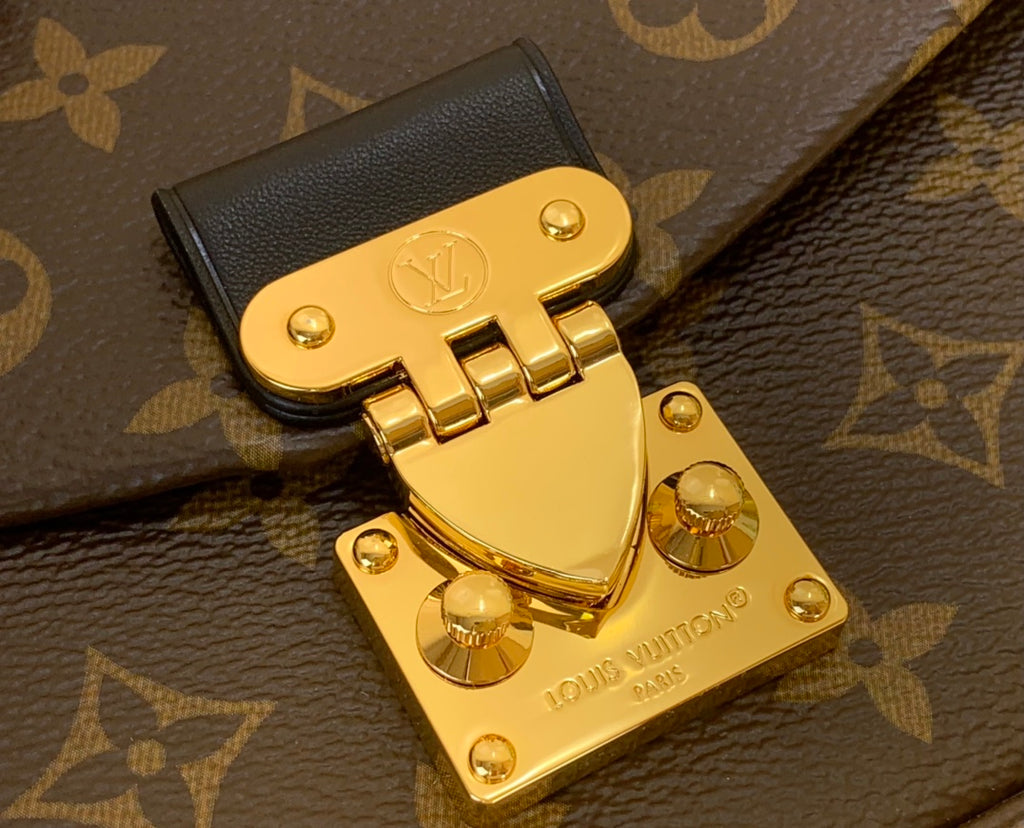 Louis Vuitton gold-tone lock plate on monogram canvas bag flap