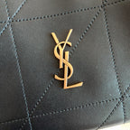 Saint Laurent YSL gold logo plaque on black quilted leather bag front