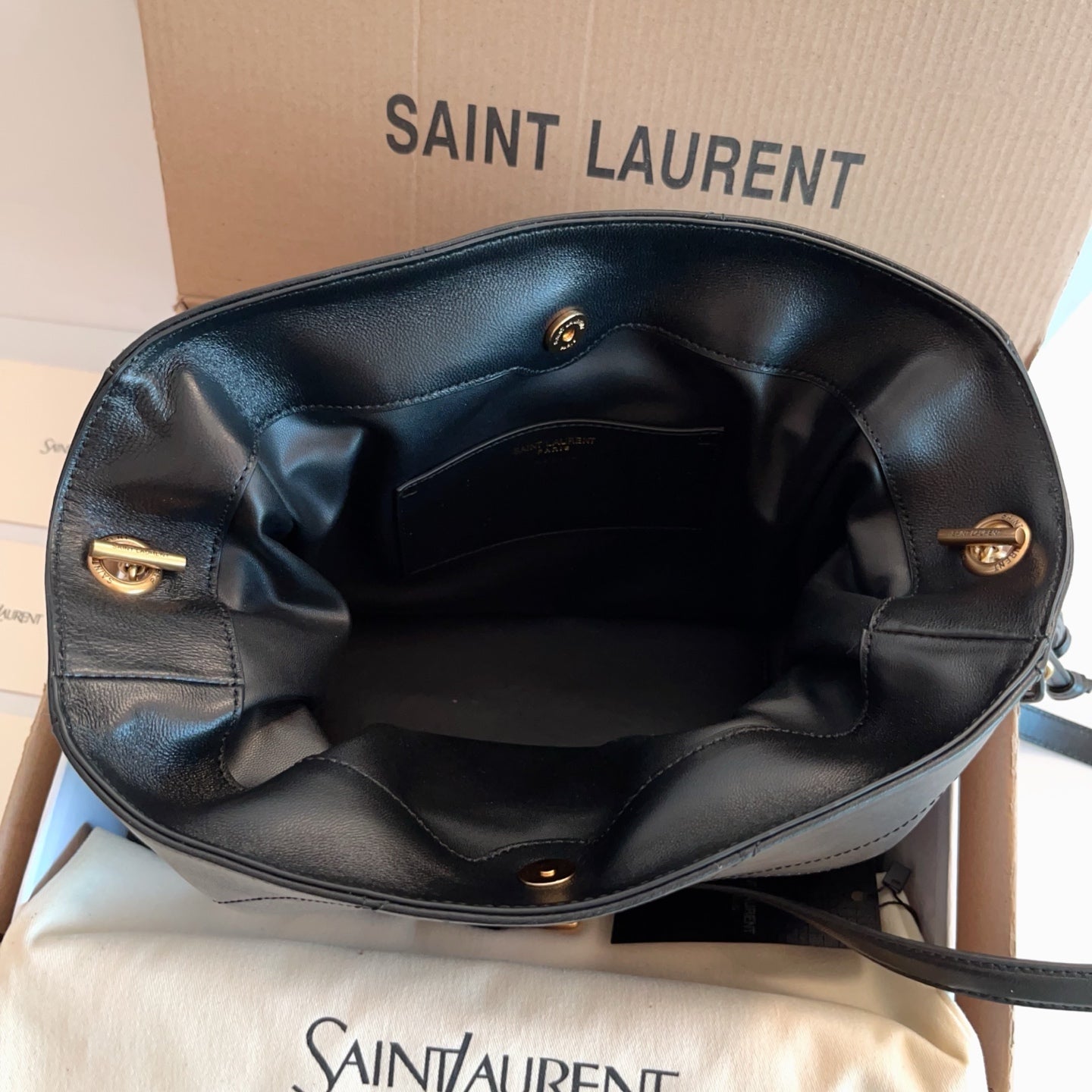 Saint Laurent bag open top with black interior lining and gold hardware details