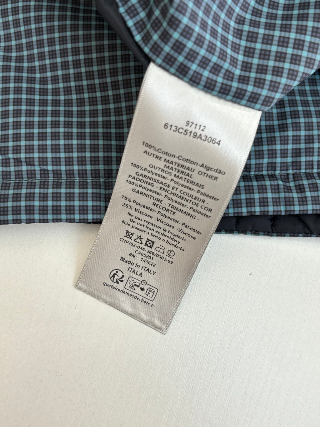 Clothing care label on checkered shirt fabric, 100% cotton