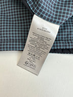 Clothing care label on checkered shirt fabric, 100% cotton