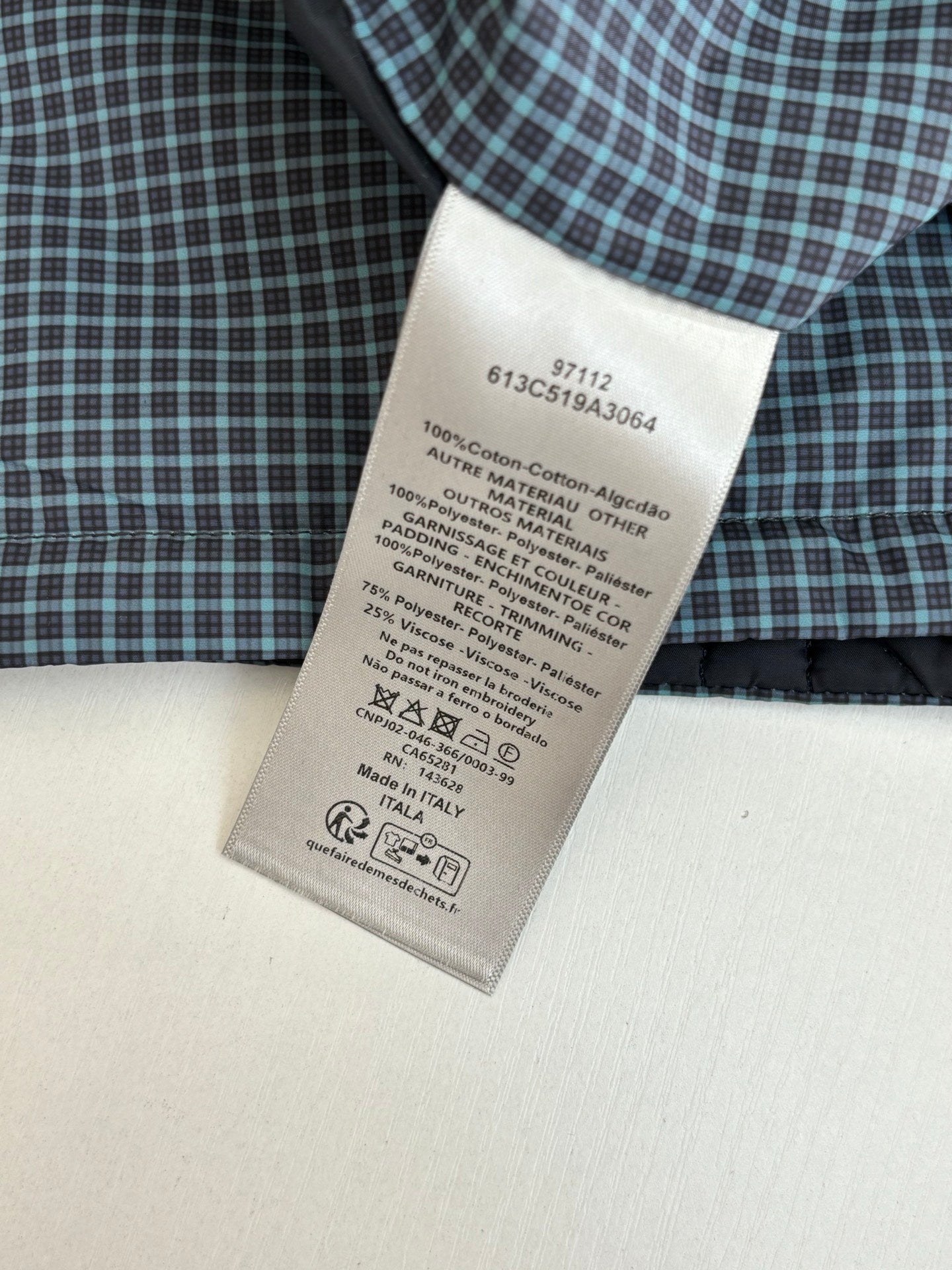 Clothing care label on checkered shirt fabric, 100% cotton