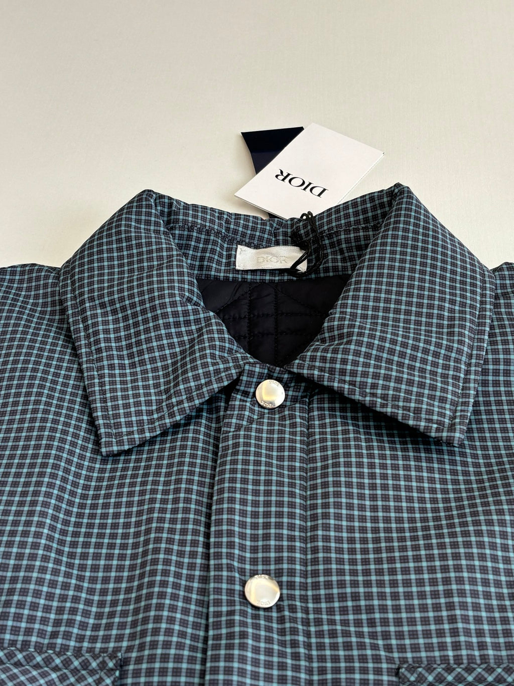 Blue check shirt jacket with pointed collar, front buttons, and matching pocket flaps