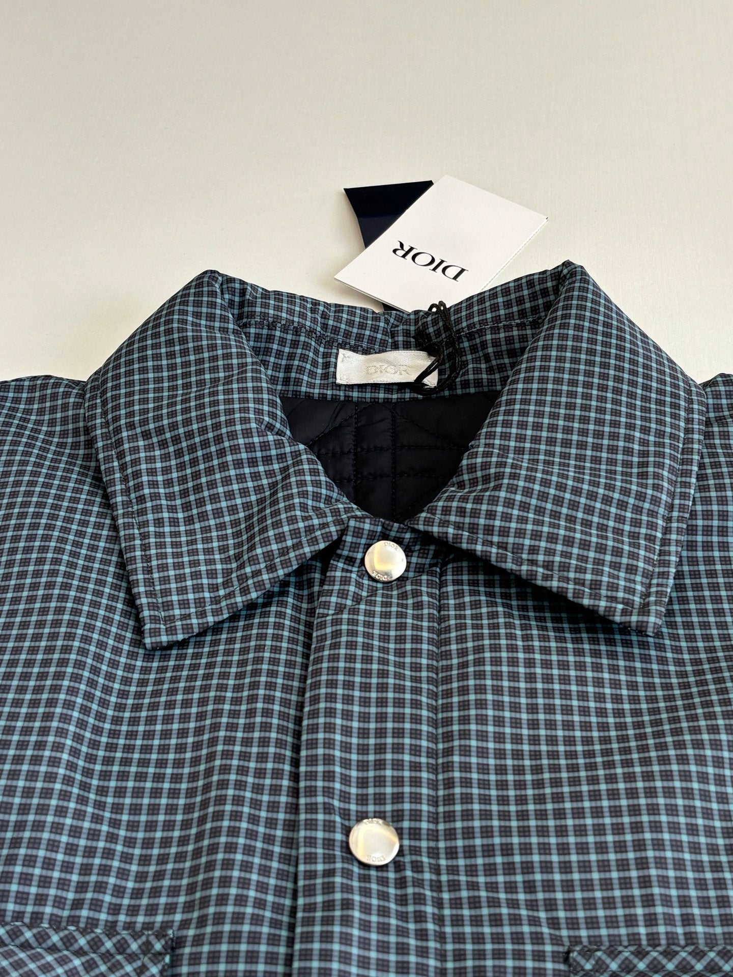 Blue check shirt jacket with pointed collar, front buttons, and matching pocket flaps