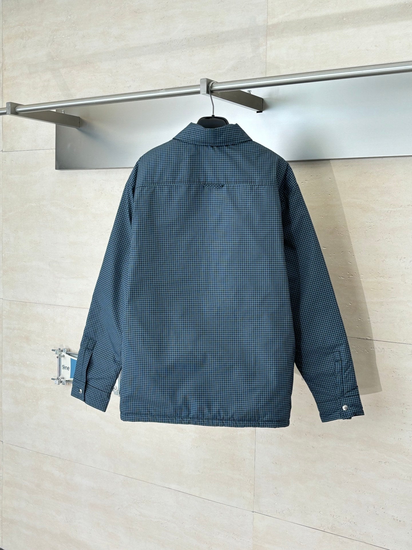 Blue check jacket with stand collar and long sleeves, button closure, logo detail