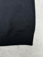 Black sweater hem with ribbed knit edge.