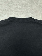 Black sweater back with ribbed crewneck collar detail.