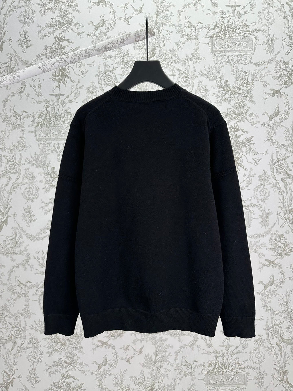 Black crewneck knit sweater, long sleeves, back view with ribbed hem and cuffs.