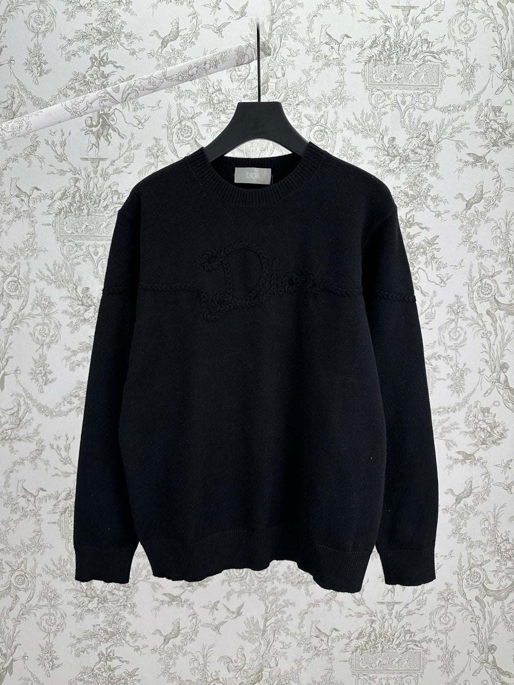 Black crewneck knit sweater with ribbed cuffs and hem, long sleeves.