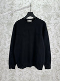 Black crewneck knit sweater with ribbed cuffs and hem, long sleeves.