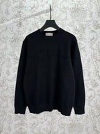 Black crewneck knit sweater with ribbed cuffs and hem, long sleeves.