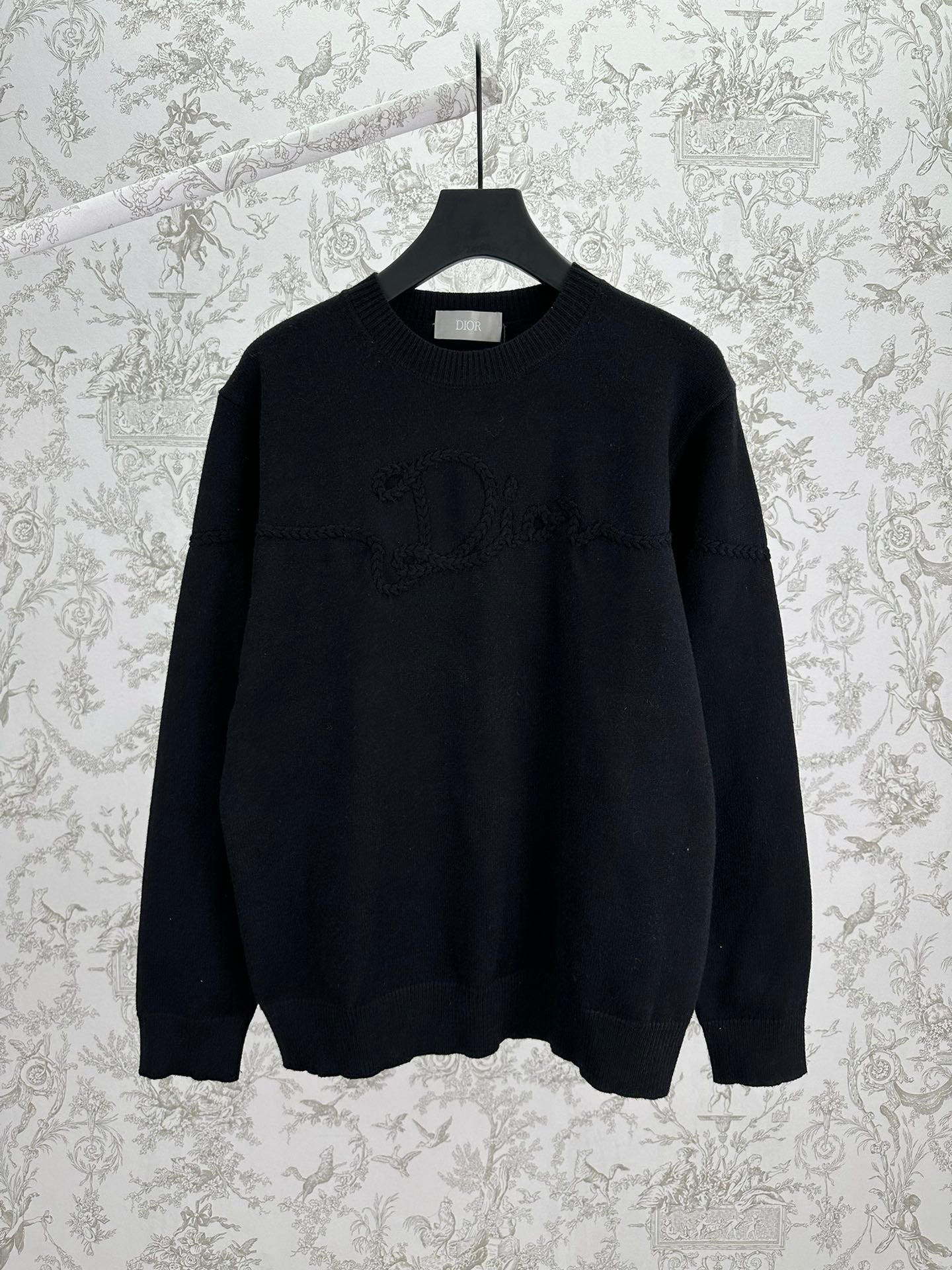 Black crewneck knit sweater with ribbed cuffs and hem, long sleeves.