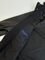 Black jacket with blue Louis Vuitton logo patch on chest and front zipper line.
