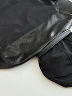 Dark long sleeve jacket, close view of embossed logo sleeve detail