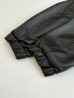 Dark long sleeve jacket, cuff and gathered hem close-up