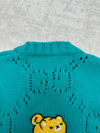 Turquoise knit sweater back with teddy bear patch and textured stitch pattern