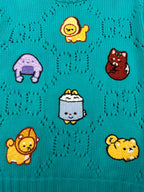 Turquoise knit sweater with cartoon animal patches across the front