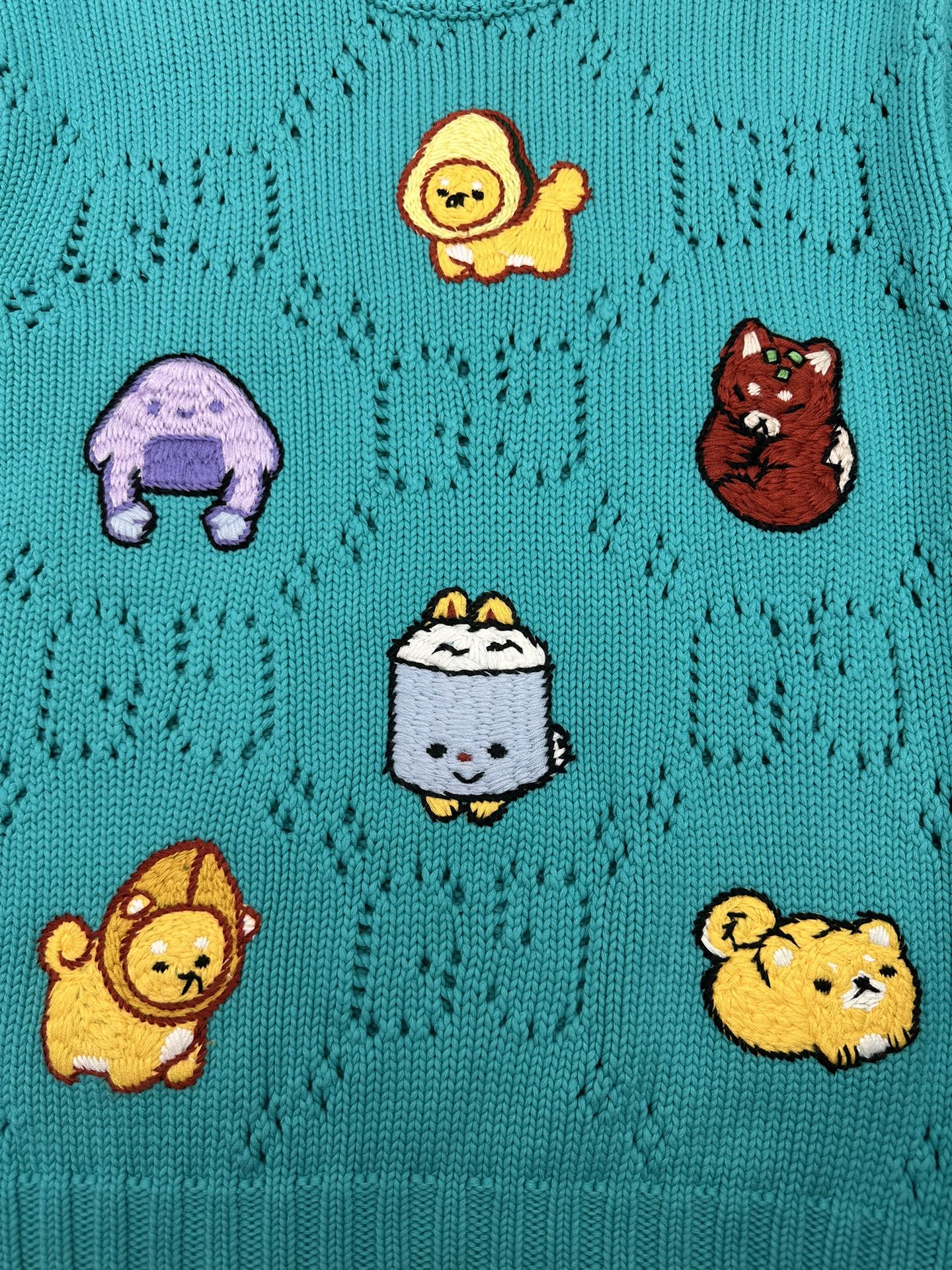 Turquoise knit sweater with cartoon animal patches across the front
