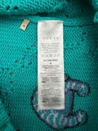 Turquoise sweater care label with Gucci branding and size M