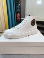 White lace-up high-top sneaker with circular logo patch and chunky sole.