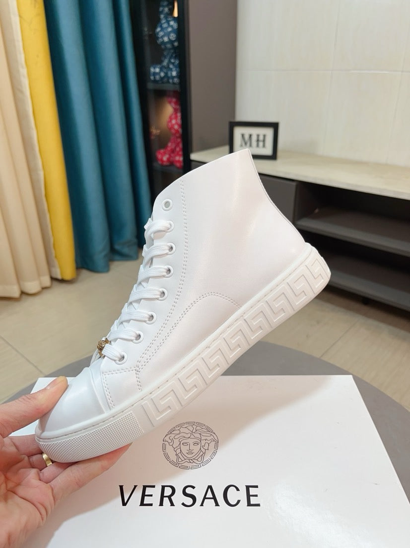 White high-top sneaker with raised logo on the side and patterned rubber sole.
