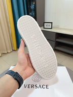 Outsole view of white high-top sneaker with textured logo pattern tread.