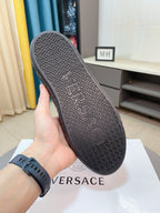 High-top sneaker outsole with repeating geometric pattern, held in a hand.