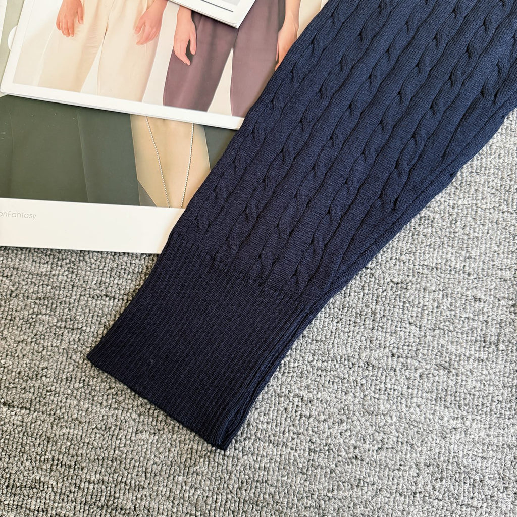 Navy cable-knit cardigan sleeve with ribbed cuff and textured knit body